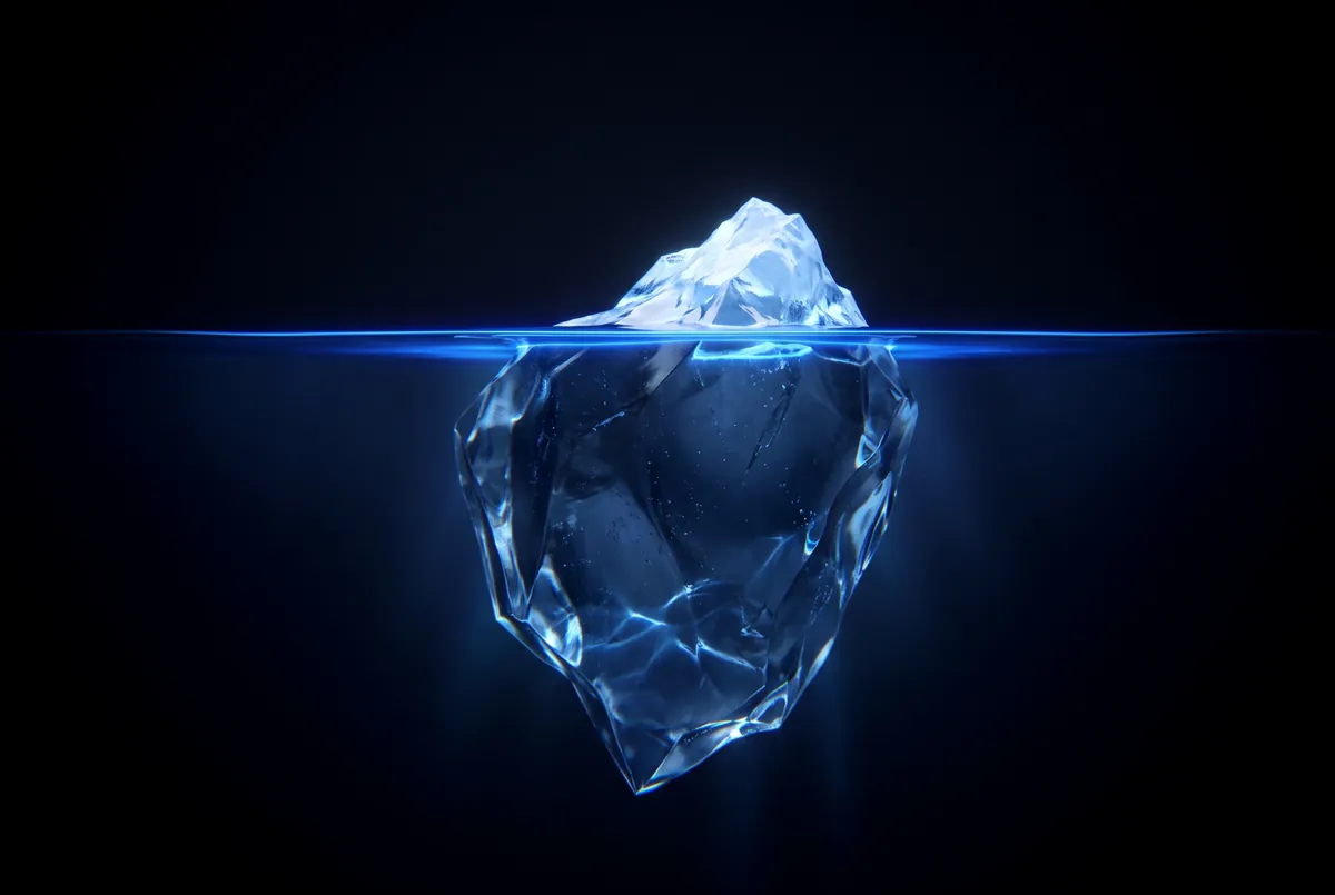 A glass iceberg with a small tip above a glowing waterline