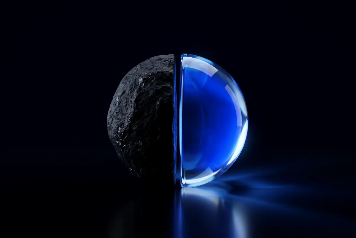 A sphere split into a stone half and a glowing glass half